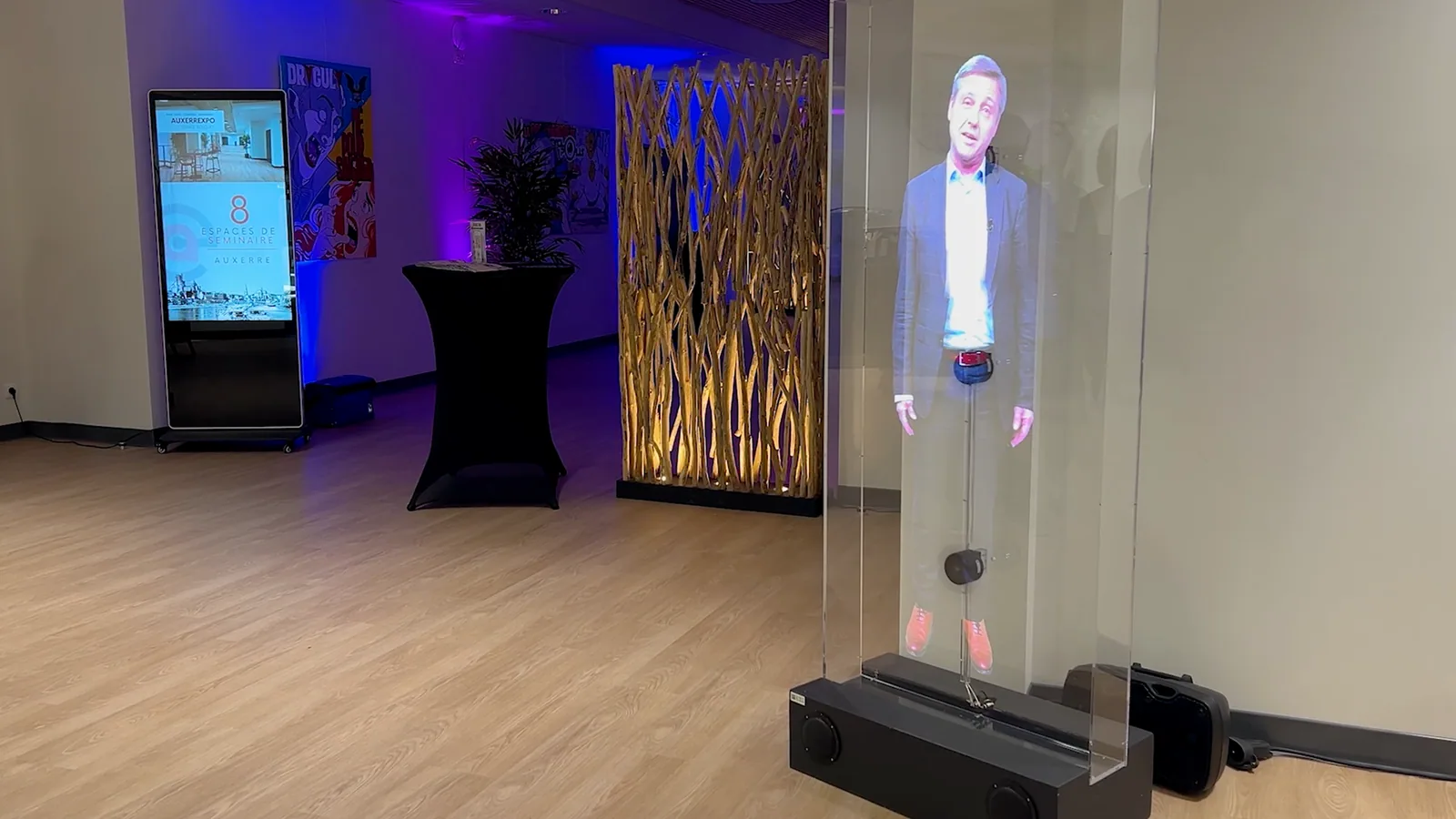 A holographic speaker displayed inside a transparent screen at a corporate event